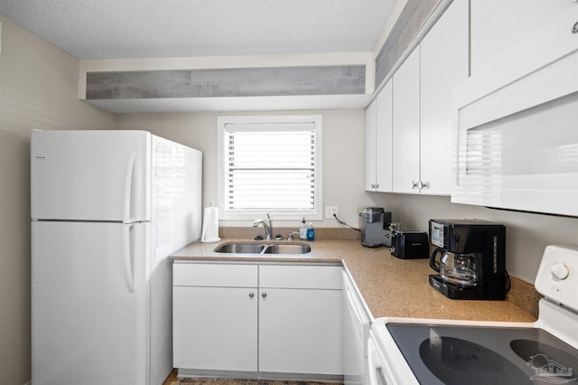 kitchen featuring a textured ceiling, sink, white cabinets, and white appliances