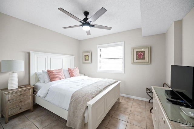 tiled bedroom with ceiling fan and a textured ceiling