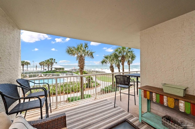 balcony with a water view and a beach view