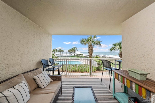 balcony featuring outdoor lounge area and a water view