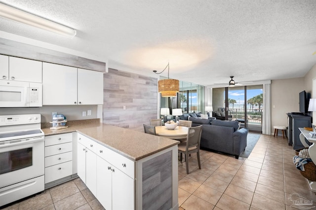 kitchen featuring white cabinets, white appliances, kitchen peninsula, and a textured ceiling