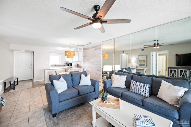 living room featuring tile patterned flooring, a textured ceiling, and ceiling fan