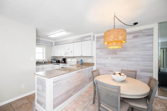kitchen with pendant lighting, white cabinetry, white appliances, and kitchen peninsula