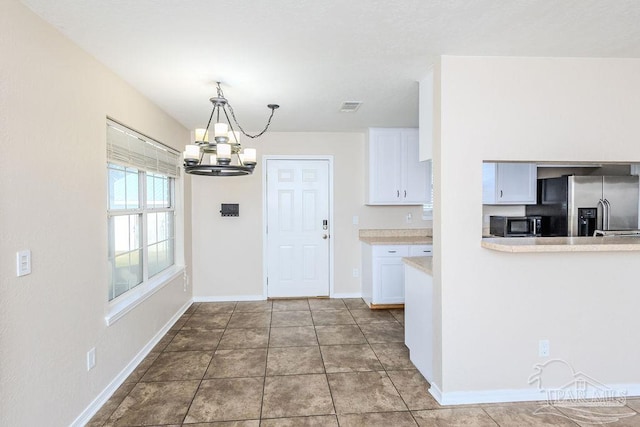 kitchen featuring hanging light fixtures, white cabinets, a chandelier, and stainless steel refrigerator with ice dispenser