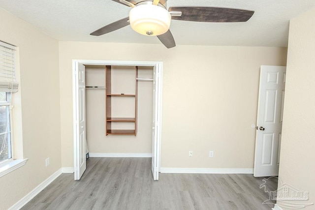 unfurnished bedroom with ceiling fan, light hardwood / wood-style flooring, and a closet