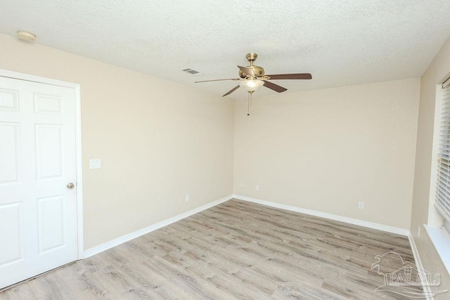 unfurnished room with a textured ceiling, light wood-type flooring, and ceiling fan