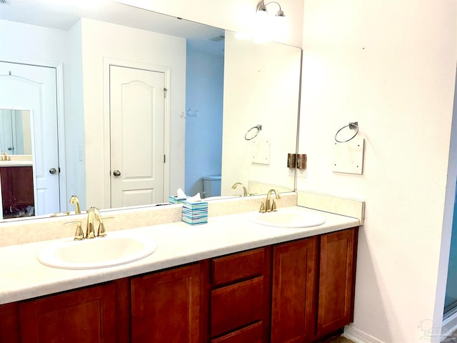 bathroom with double sink vanity and toilet