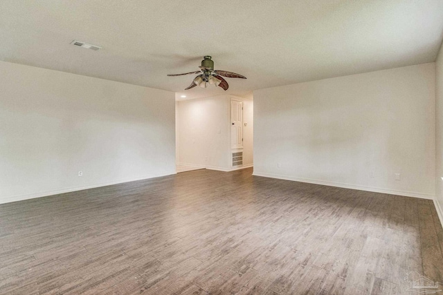 empty room with ceiling fan and dark wood-type flooring