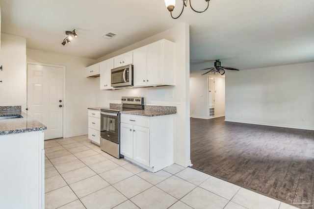 kitchen with white cabinetry, light tile patterned floors, and stainless steel appliances