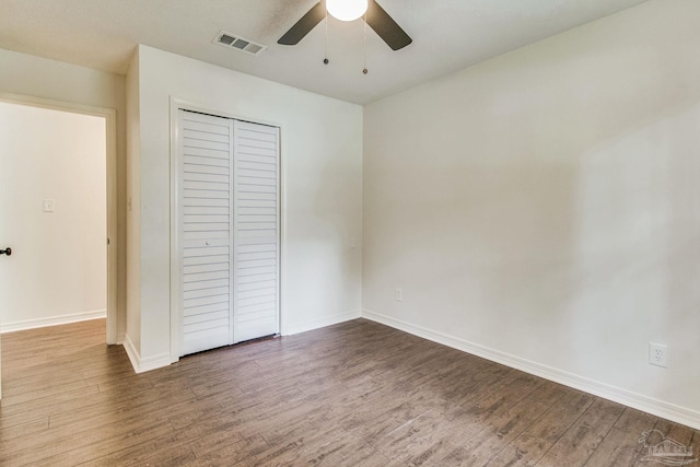 unfurnished bedroom with ceiling fan, a closet, and hardwood / wood-style flooring