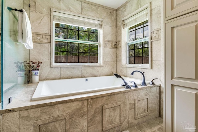 bathroom featuring tiled tub and tile walls