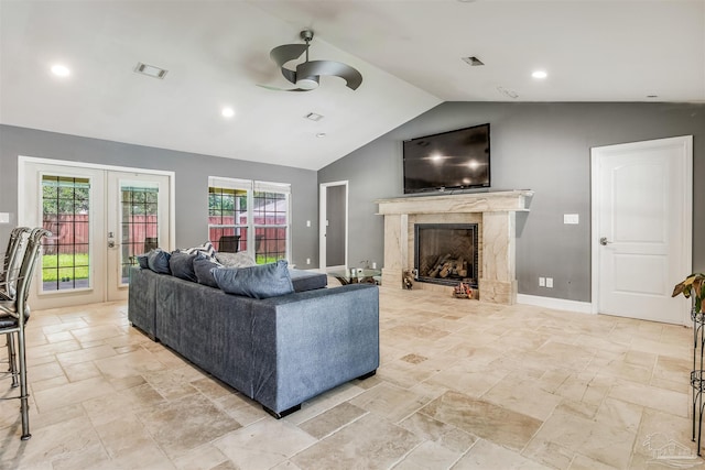 living room featuring a fireplace, french doors, vaulted ceiling, and ceiling fan