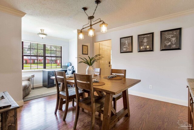3905 Tiger Point Blvd, Gulf Breeze, FL 32563 - dining room with dark wood-style floors, ornamental molding, a textured ceiling, and baseboards
