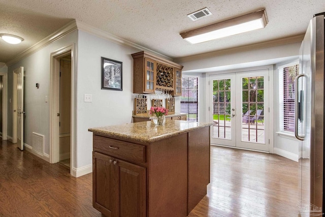 3905 Tiger Point Blvd, Gulf Breeze, FL 32563 - kitchen with french doors, crown molding, dark wood-style flooring, a textured ceiling, and glass insert cabinets