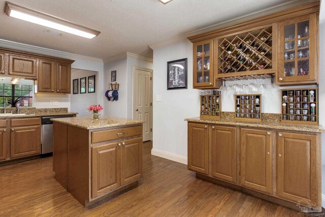 3905 Tiger Point Blvd, Gulf Breeze, FL 32563 - kitchen with ornamental molding, dark wood finished floors, a kitchen island, a sink, and brown cabinets