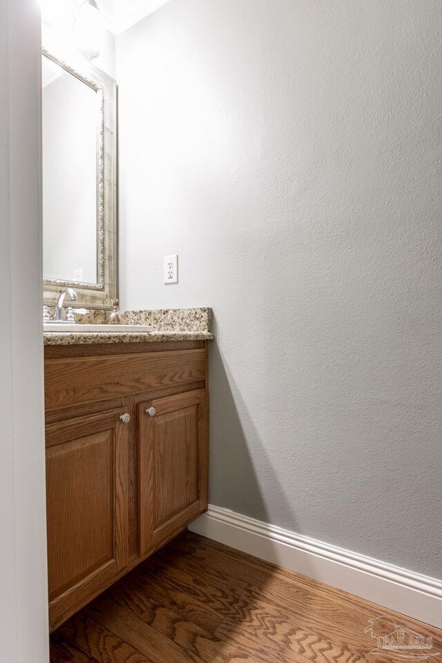 3905 Tiger Point Blvd, Gulf Breeze, FL 32563 - bathroom with wood finished floors, vanity, and baseboards