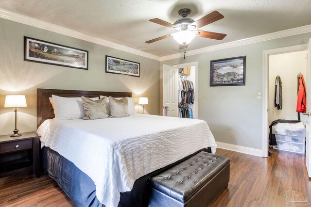 3905 Tiger Point Blvd, Gulf Breeze, FL 32563 - bedroom featuring wood finished floors, ornamental molding, baseboards, a walk in closet, and a ceiling fan