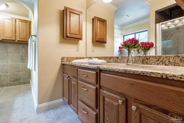 3905 Tiger Point Blvd, Gulf Breeze, FL 32563 - full bath featuring ornamental molding, double vanity, tile patterned flooring, and tiled shower