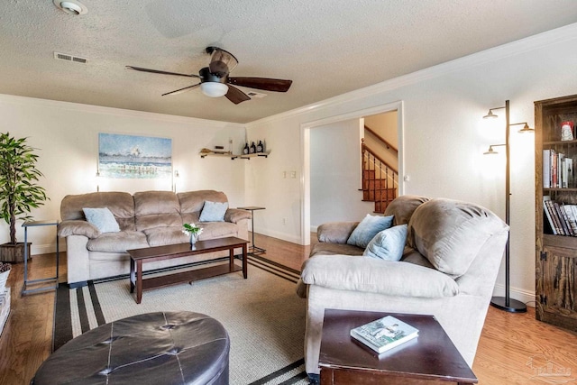 3905 Tiger Point Blvd, Gulf Breeze, FL 32563 - living room featuring stairs, a ceiling fan, crown molding, wood finished floors, and a textured ceiling