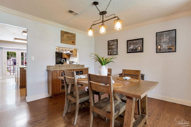 3905 Tiger Point Blvd, Gulf Breeze, FL 32563 - dining room with ornamental molding, dark wood-style flooring, baseboards, a textured ceiling, and french doors