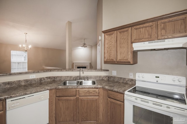 kitchen with white appliances, ceiling fan with notable chandelier, sink, hanging light fixtures, and kitchen peninsula