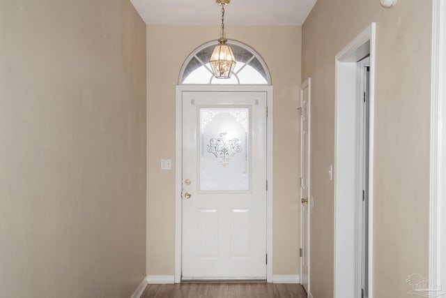 entrance foyer featuring wood-type flooring and an inviting chandelier