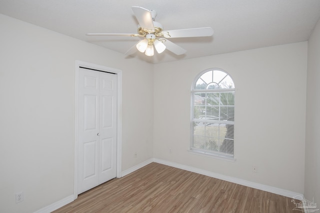 empty room with light hardwood / wood-style flooring and ceiling fan