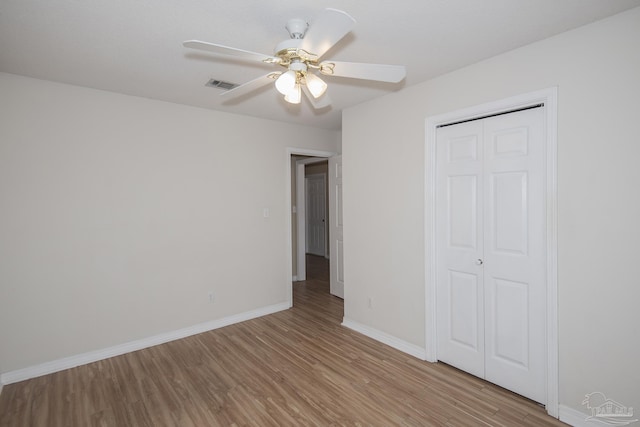 unfurnished bedroom with ceiling fan, light hardwood / wood-style floors, and a closet