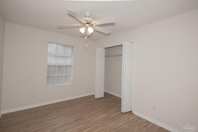 unfurnished bedroom with ceiling fan, a closet, and hardwood / wood-style flooring