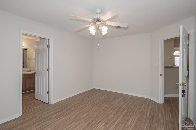 unfurnished room featuring light wood-type flooring, ceiling fan, and sink