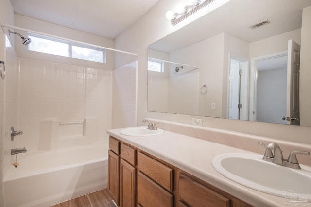 bathroom with hardwood / wood-style floors, vanity, and shower / tub combination