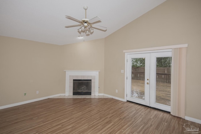 unfurnished living room featuring french doors, vaulted ceiling, ceiling fan, a fireplace, and hardwood / wood-style floors