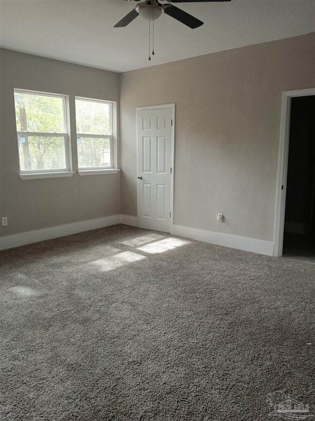 carpeted spare room featuring ceiling fan