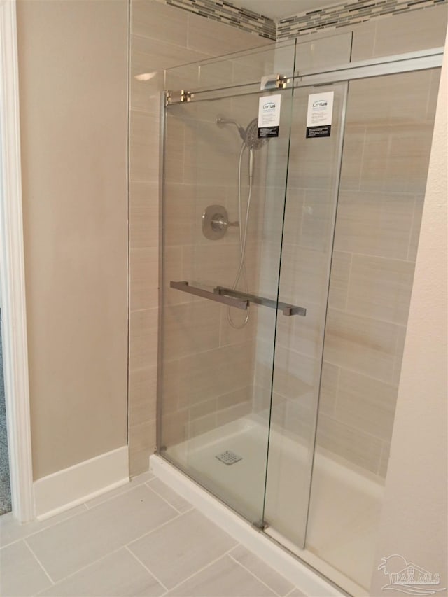 bathroom featuring an enclosed shower and tile patterned floors