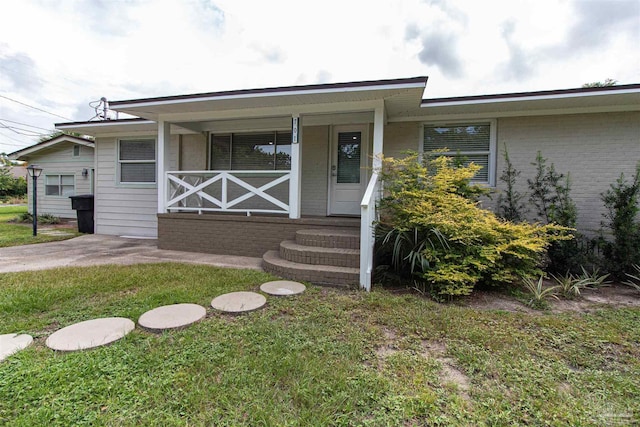 property entrance with a yard and covered porch