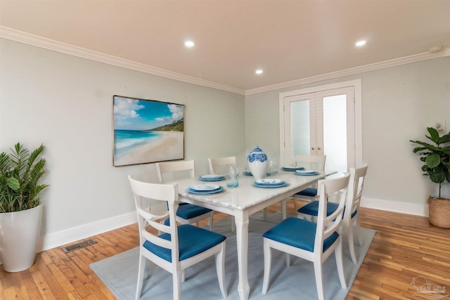 dining area featuring ornamental molding, hardwood / wood-style floors, and french doors