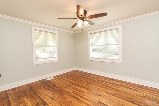 unfurnished room with crown molding, wood-type flooring, and plenty of natural light