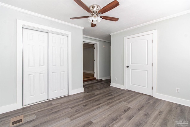 unfurnished bedroom with a closet, ornamental molding, dark hardwood / wood-style floors, and ceiling fan