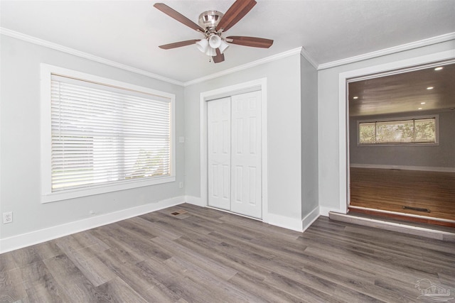 unfurnished bedroom featuring dark hardwood / wood-style flooring, ornamental molding, ceiling fan, and a closet