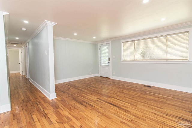 empty room featuring crown molding and wood-type flooring