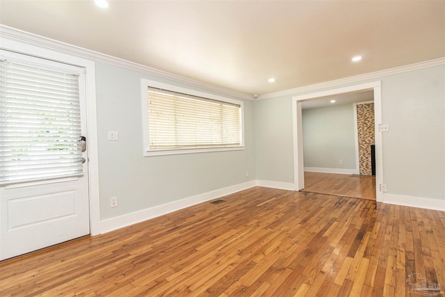 unfurnished room with hardwood / wood-style flooring, a fireplace, and crown molding