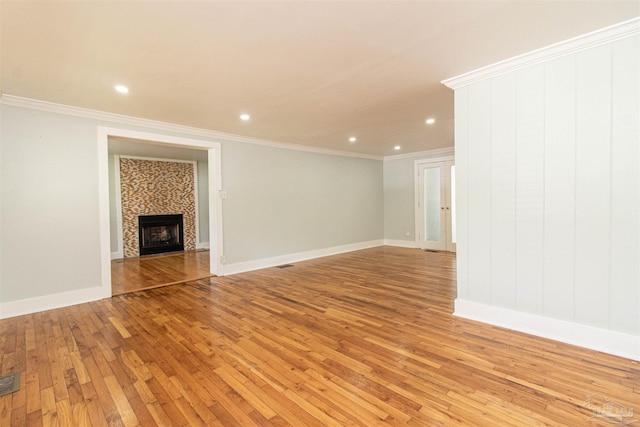 unfurnished living room with a fireplace, ornamental molding, and light hardwood / wood-style floors