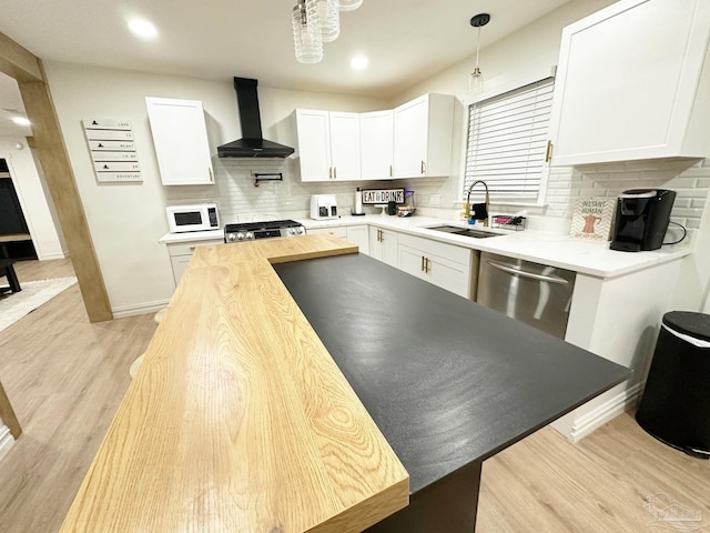 kitchen with range, a sink, dishwasher, wall chimney range hood, and white microwave