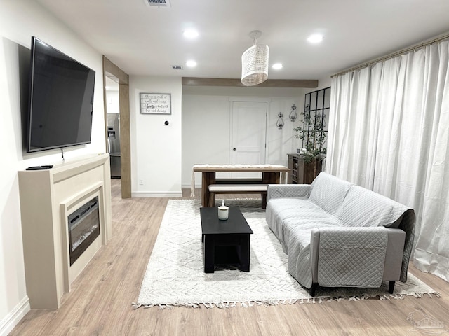 living area with recessed lighting, baseboards, visible vents, and light wood-type flooring