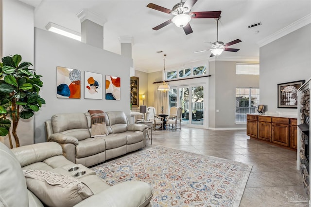 living room with ceiling fan, crown molding, and a towering ceiling