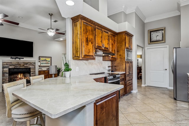 kitchen featuring stainless steel appliances, tasteful backsplash, a kitchen breakfast bar, kitchen peninsula, and crown molding