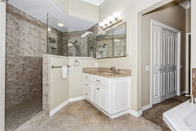 bathroom featuring vanity, tile patterned flooring, and a tile shower