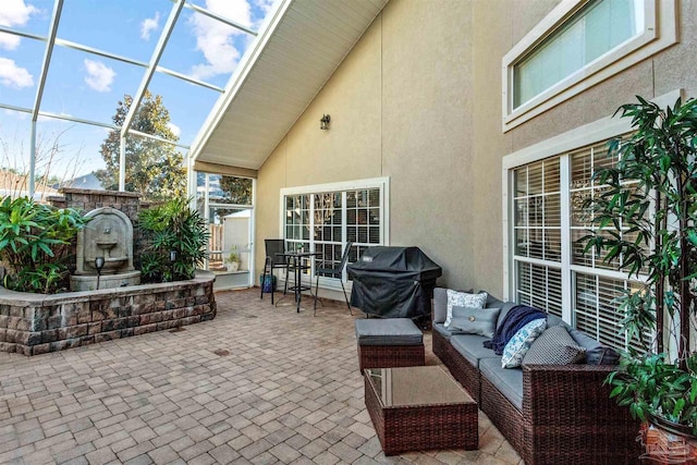 view of patio / terrace featuring glass enclosure, an outdoor living space, and grilling area