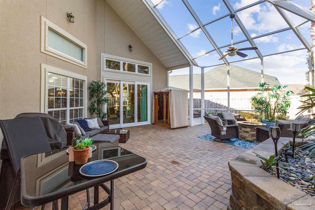 view of patio / terrace featuring a lanai and an outdoor living space with a fire pit