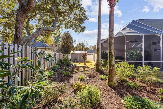 view of yard featuring ceiling fan and a lanai